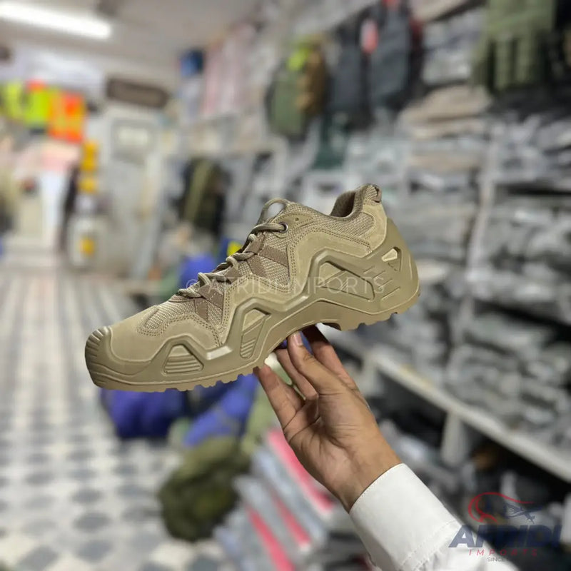 A tan, tactical-style hiking or athletic shoe with a rugged sole.