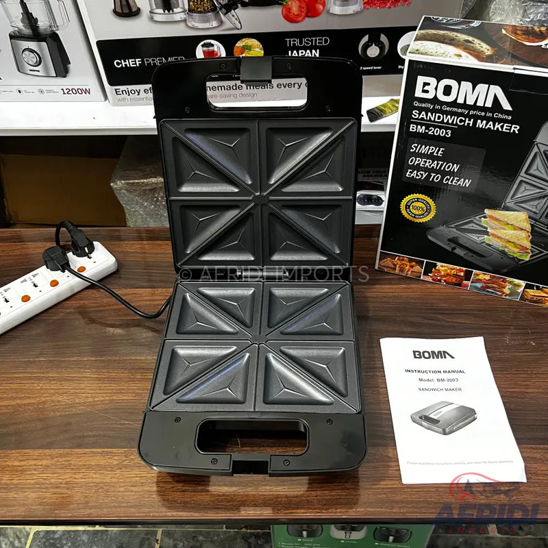 An open black electric sandwich maker with four triangular compartments.