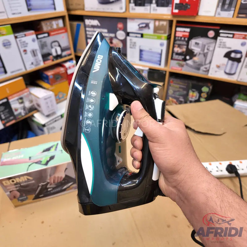 Dark green and black steam iron with a white handle.