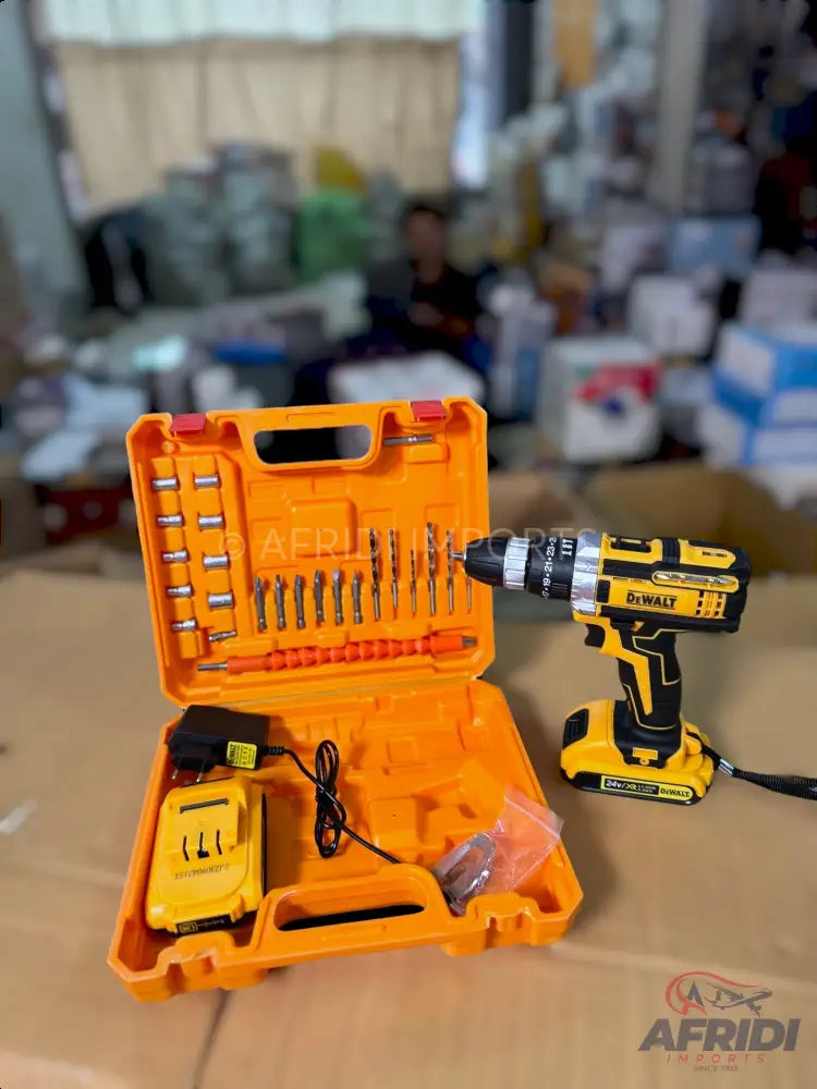 A yellow and black cordless drill with a battery, charger, and a set of various drill bits in an orange carrying case.