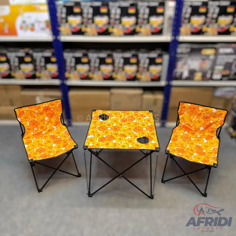Portable camping table and two chairs set with a vibrant orange and yellow floral pattern.