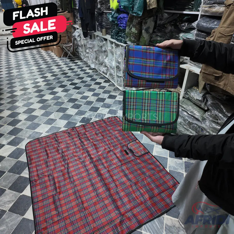 Foldable plaid picnic mats in red, blue, and green.