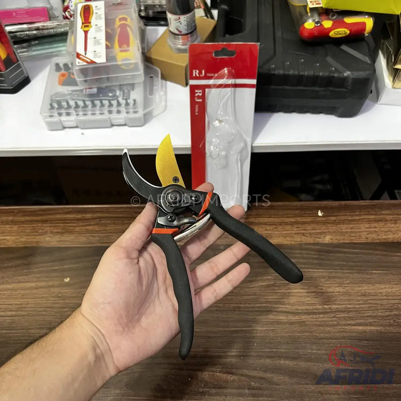 Hand-held pruning shears with black handles and a yellow blade.