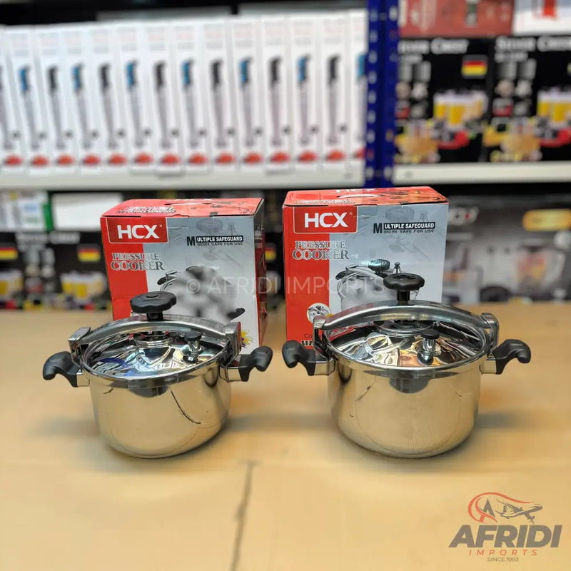 Two stainless steel pressure cookers with black handles, each in its individual retail box.
