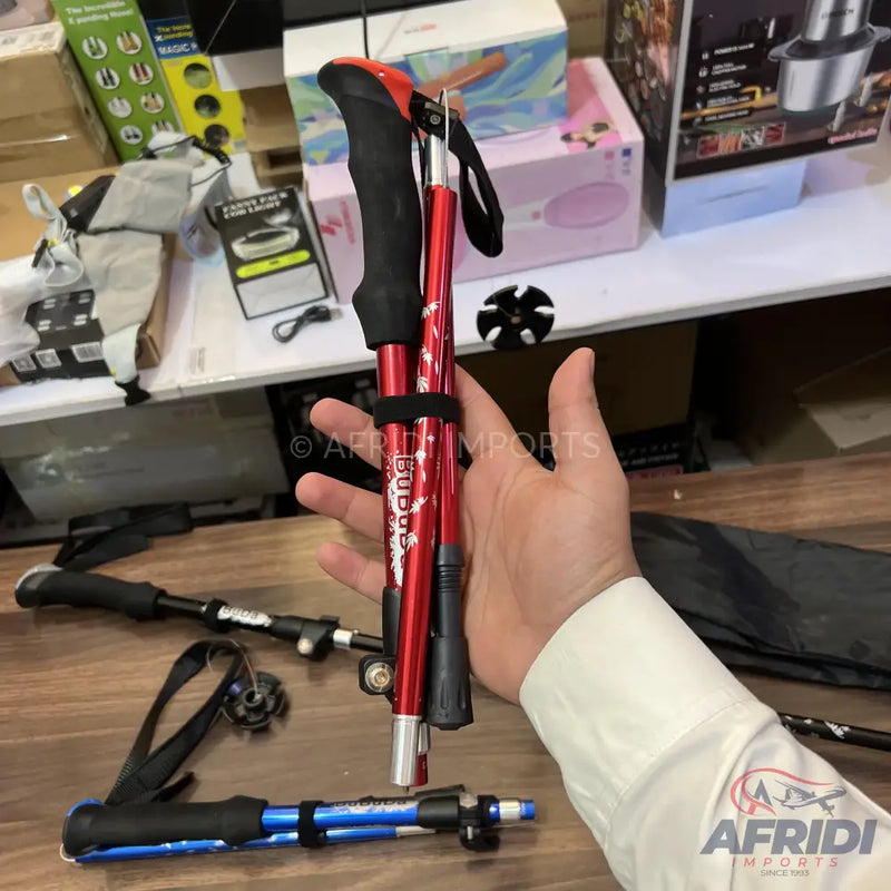 Red and blue foldable trekking poles with black grips.