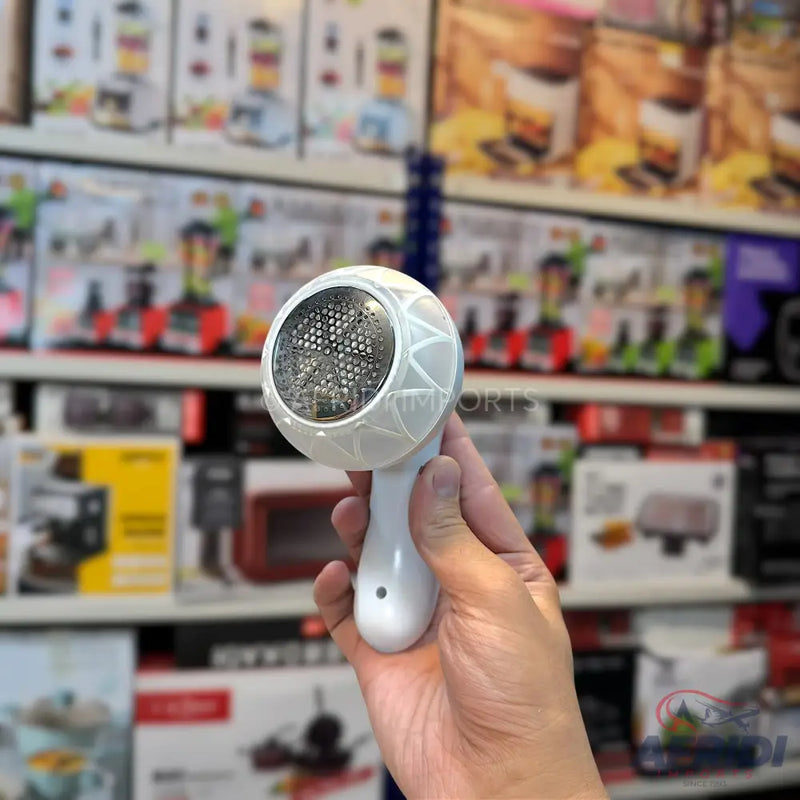 White handheld fabric shaver with a patterned head.