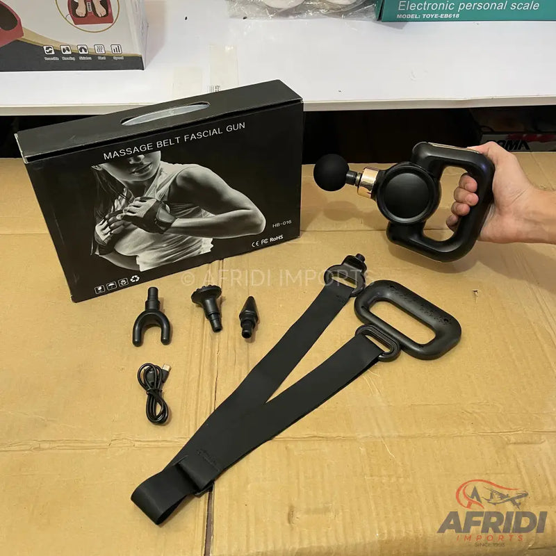 Black massage gun with multiple attachments and a belt.