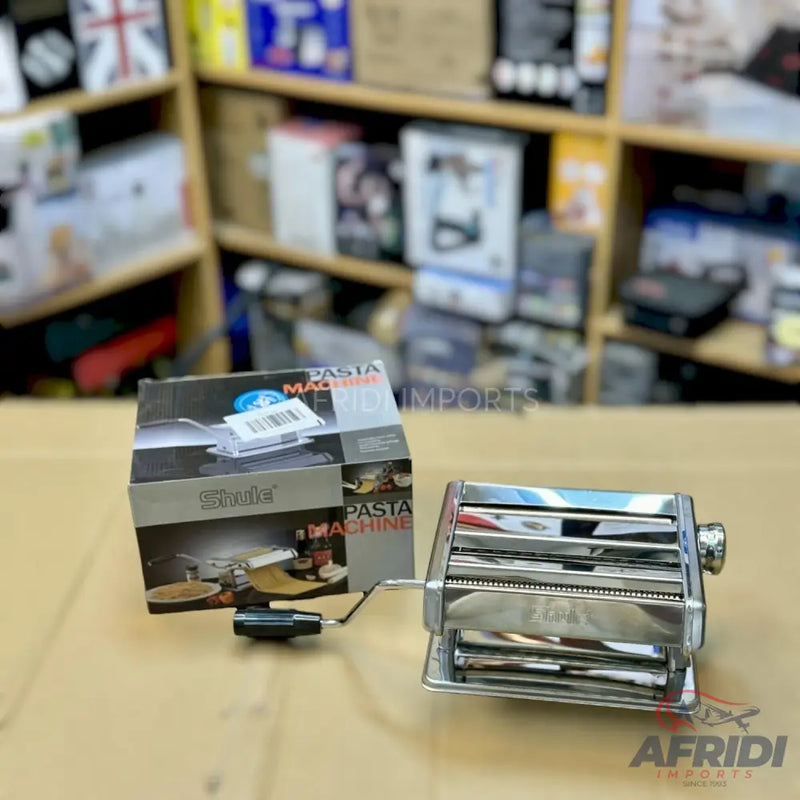 Manual chrome pasta maker with an accompanying box.