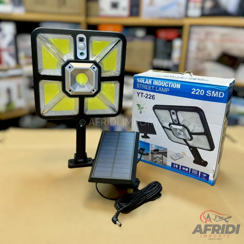 A black square solar induction street lamp with a separate solar panel.