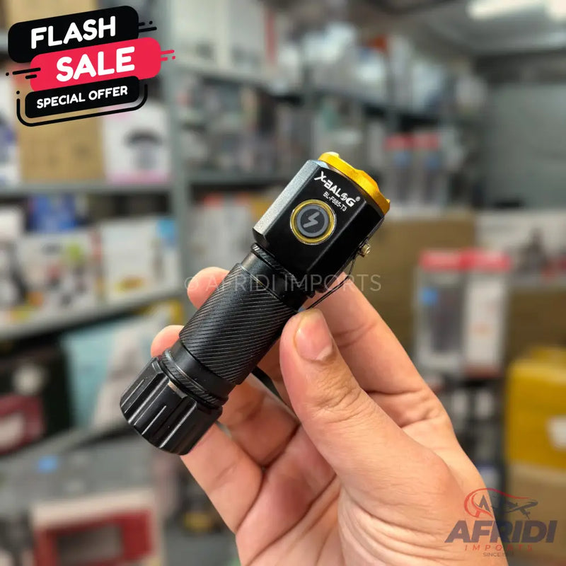 Black metal flashlight with a gold top and a lightning bolt button.