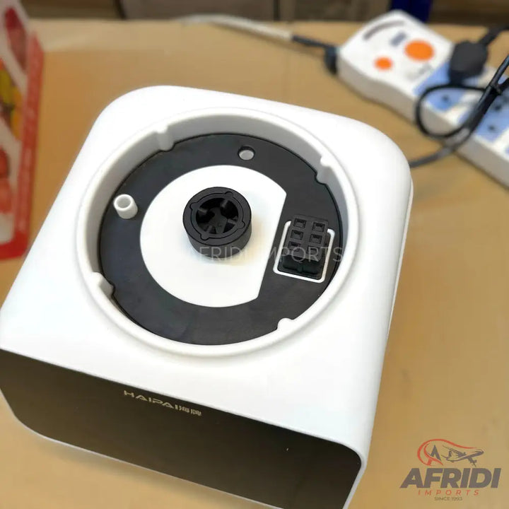 White and black humidifier with a central rotating mechanism and electrical connector.