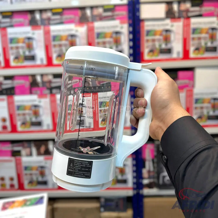A white and clear plastic blender jug with a handle, lid, and internal blades.
