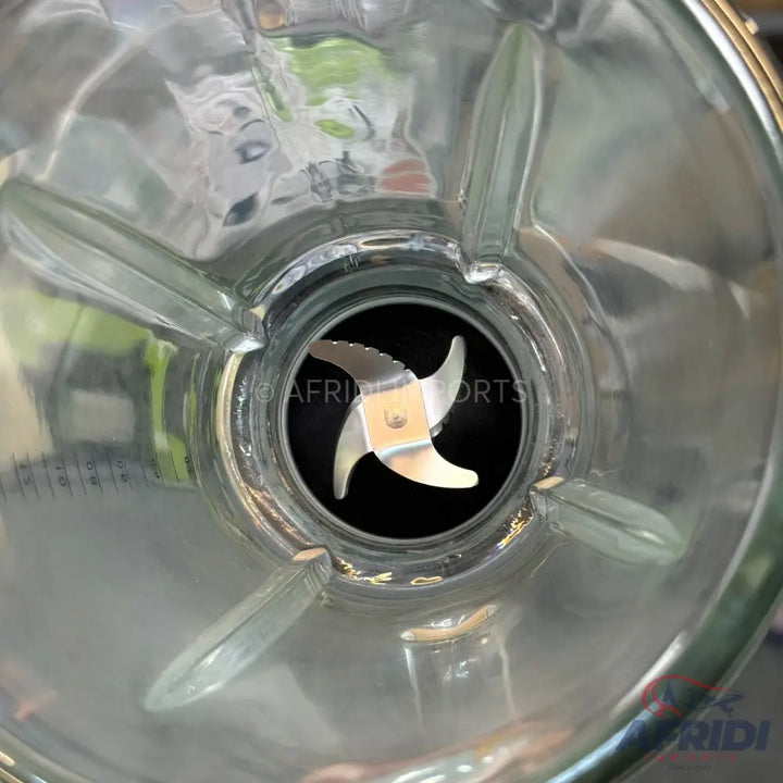 A glass blender jar with a four-pronged blade.