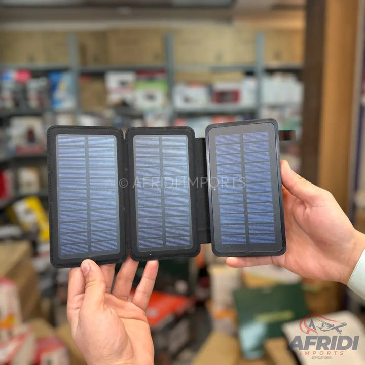 A foldable, three-panel solar charger with dark blue solar cells and a black casing.