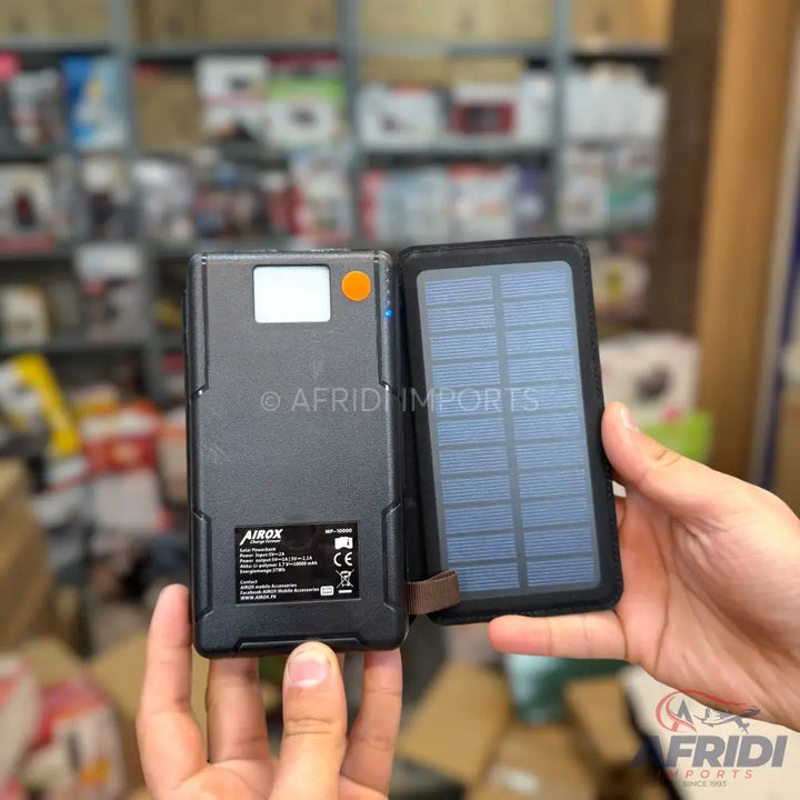 Black solar power bank with digital display and integrated flashlight.