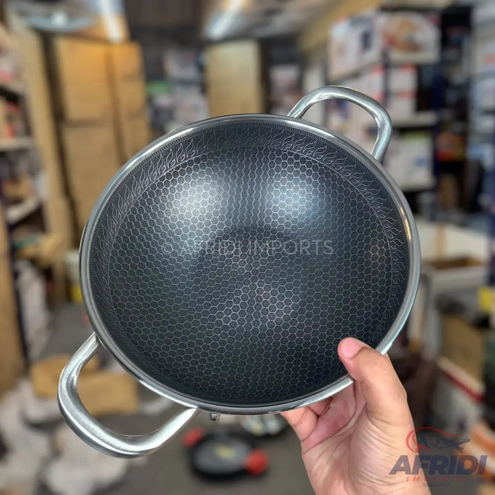 A dark, honeycomb-textured wok with two silver handles.