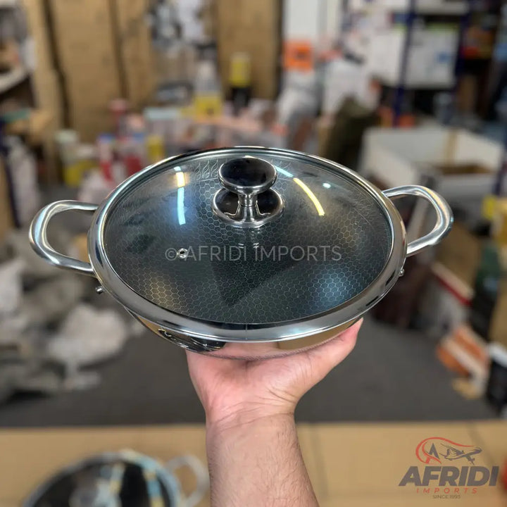 Stainless steel pot with a glass lid and two handles.