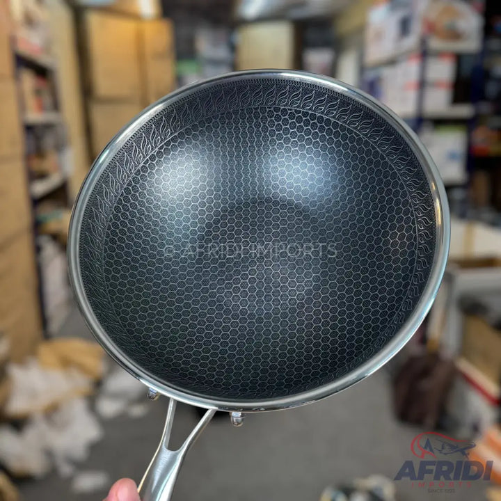 Stainless steel wok with a honeycomb non-stick interior.