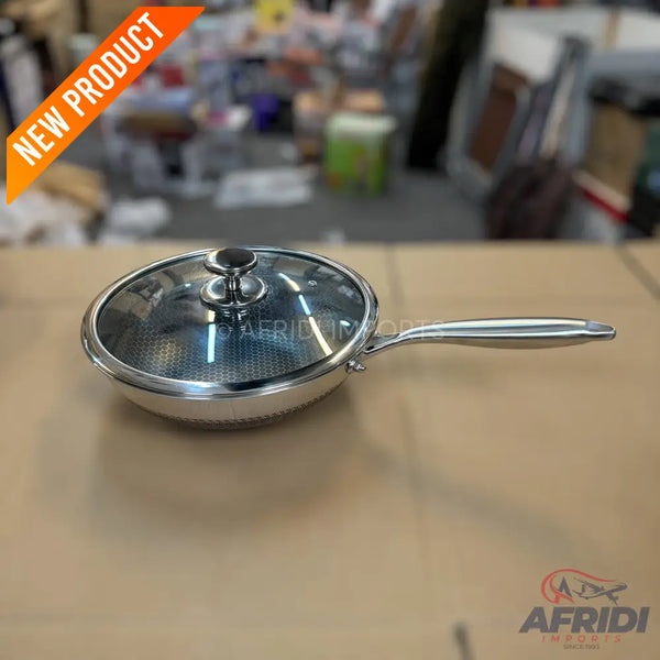A stainless steel frying pan with a glass lid and a honeycomb non-stick interior.