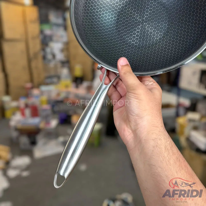 Stainless steel wok with a honeycomb non-stick pattern.