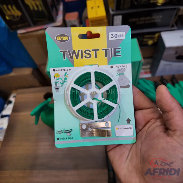 A spool of green twist tie wire with a built-in cutter, packaged for gardening or general use.