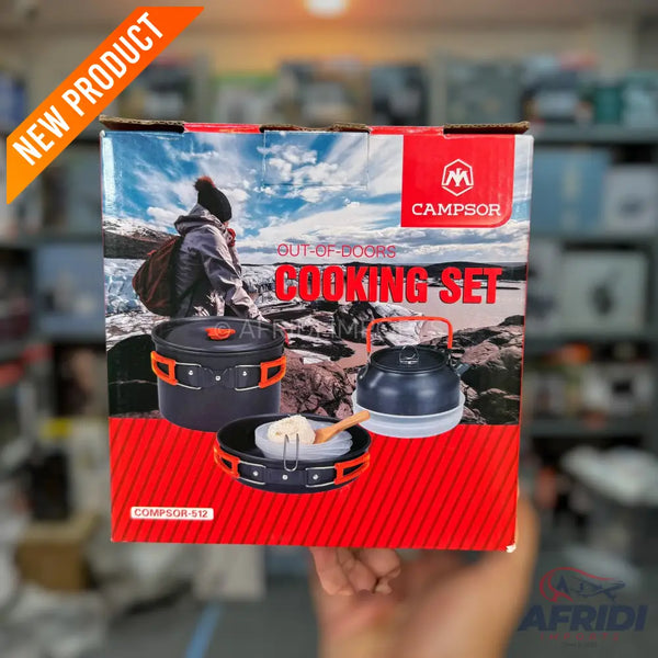 A boxed outdoor cooking set featuring a pot, kettle, and frying pan with orange accents, designed for camping.
