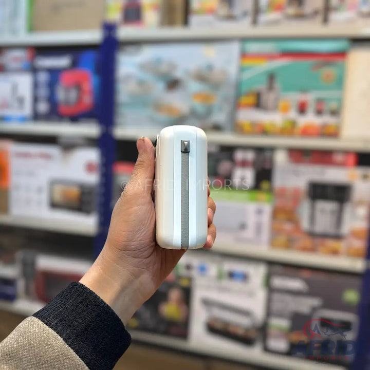 A white, cylindrical, handheld personal fan with a gray strap.