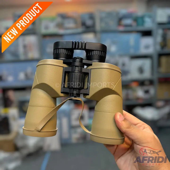 Tan-colored binoculars with black accents and a strap.