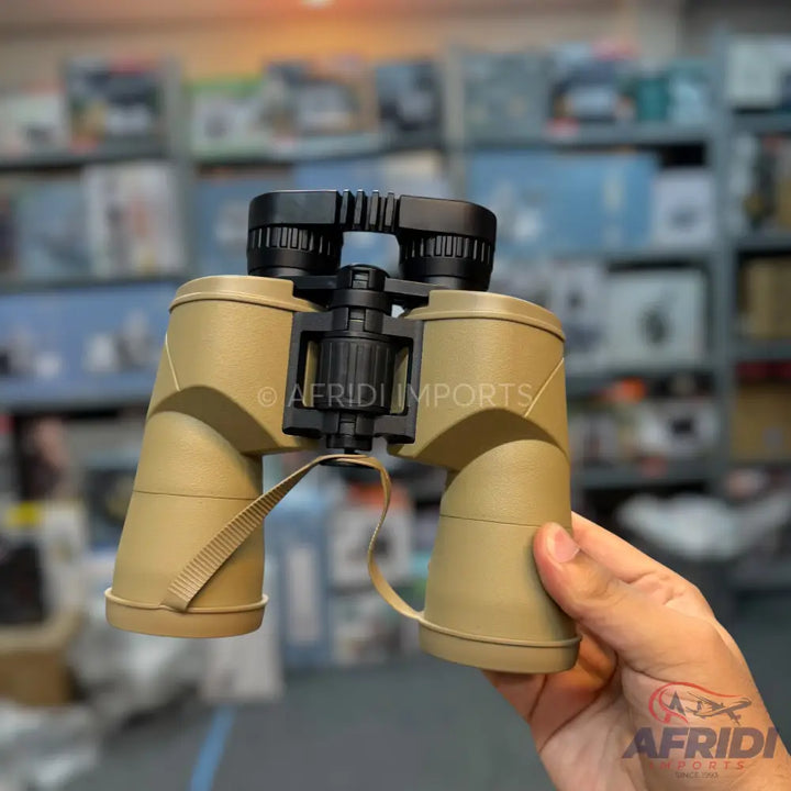 Tan-colored binoculars with black accents and a strap.