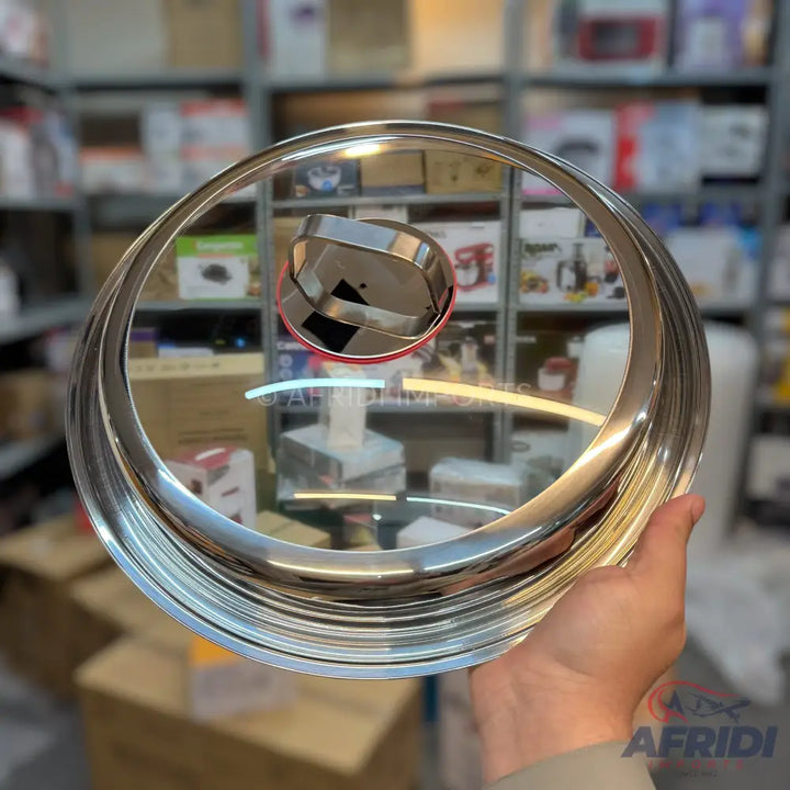 A clear glass pot lid with a polished stainless steel rim and a matching handle.