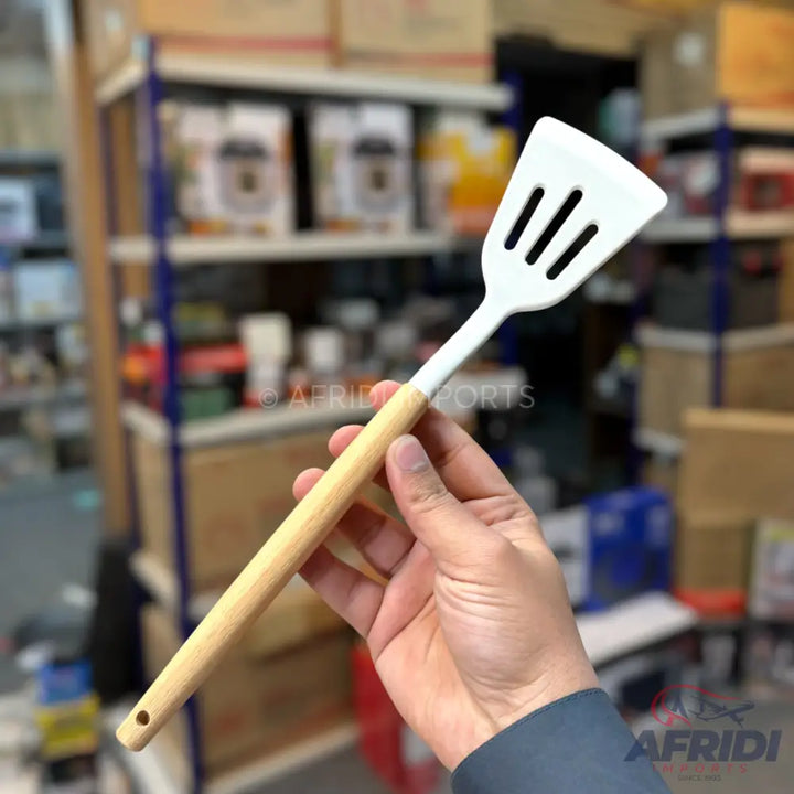 A white slotted spatula with a light wooden handle.