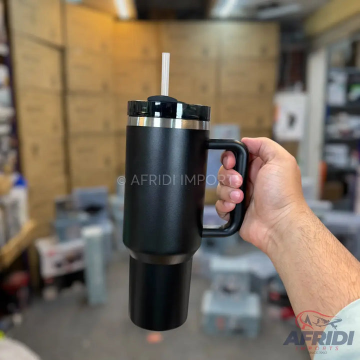 Black insulated tumbler with a handle and straw.
