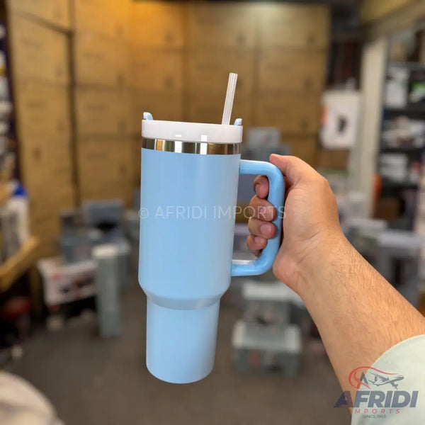 A light blue insulated travel mug with a handle, lid, and straw.