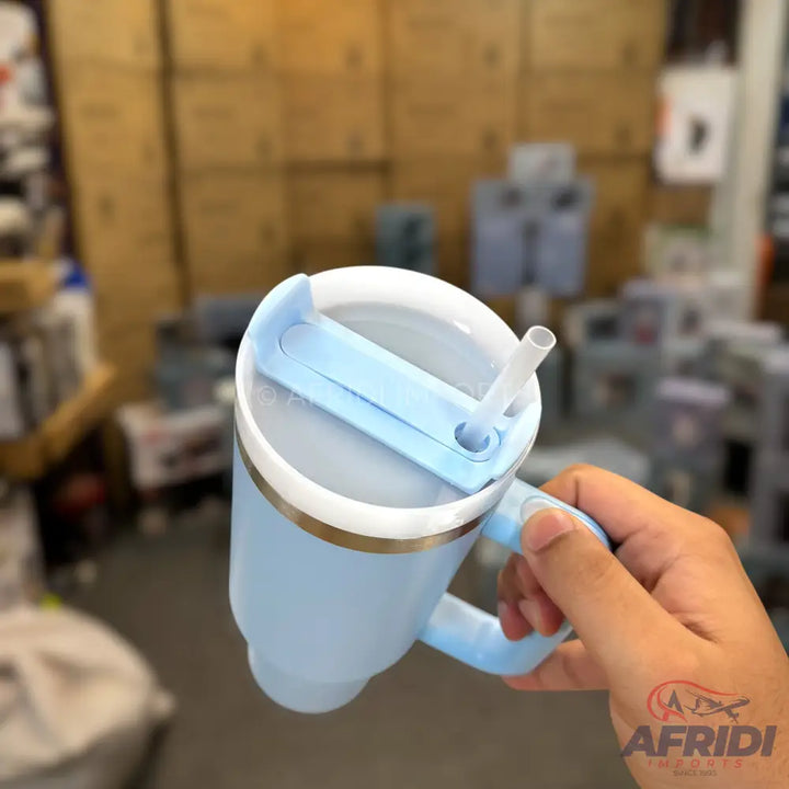 Light blue insulated mug with a handle, a white lid, and a straw.