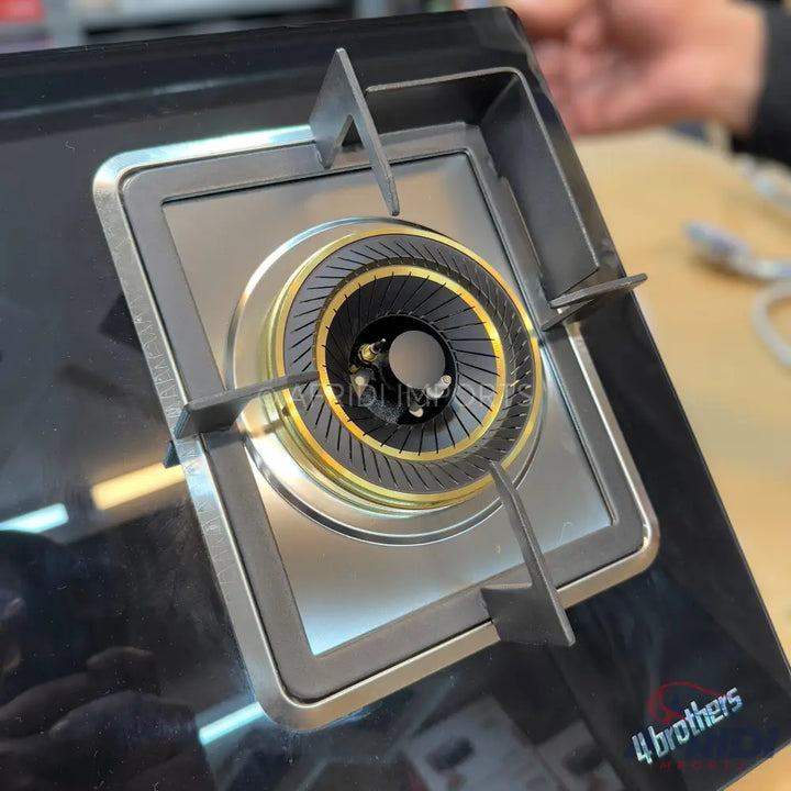 A black glass-top gas hob with a single burner and a metal grate.