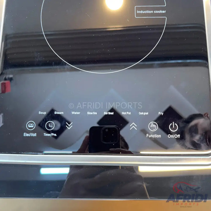 Black glass induction cooktop with touch controls and various cooking functions.