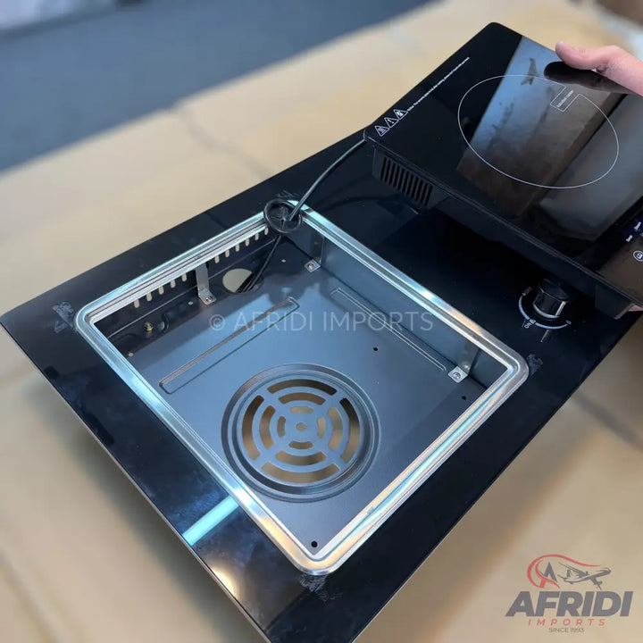 Black glass top induction and gas hob with an open burner well.