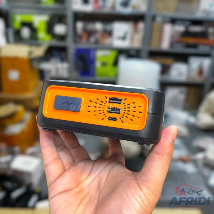 Orange and black portable power bank with multiple USB ports.