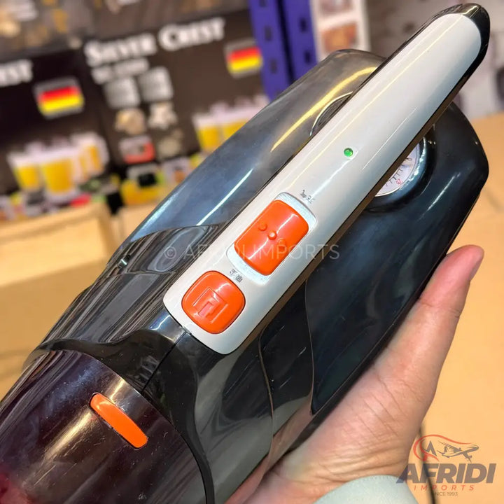 Black and white handheld car vacuum cleaner with orange buttons.