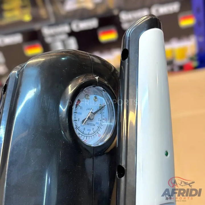 Black and white portable air compressor with an analog pressure gauge.