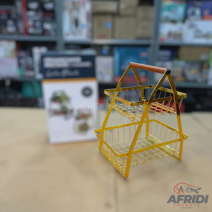 Two-tiered gold metal wire basket with a wooden handle.