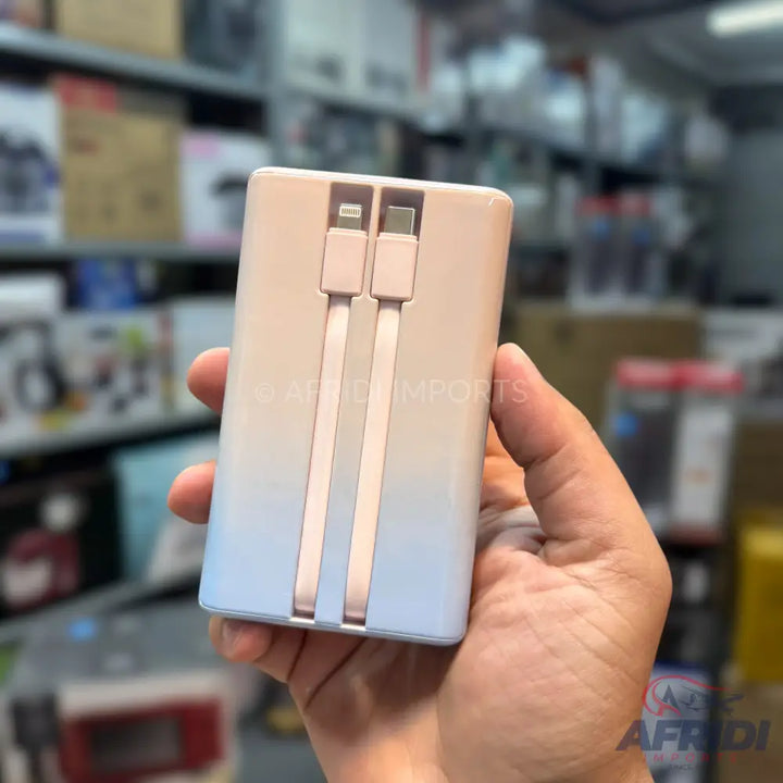 A portable power bank with built-in Lightning and USB-C charging cables.