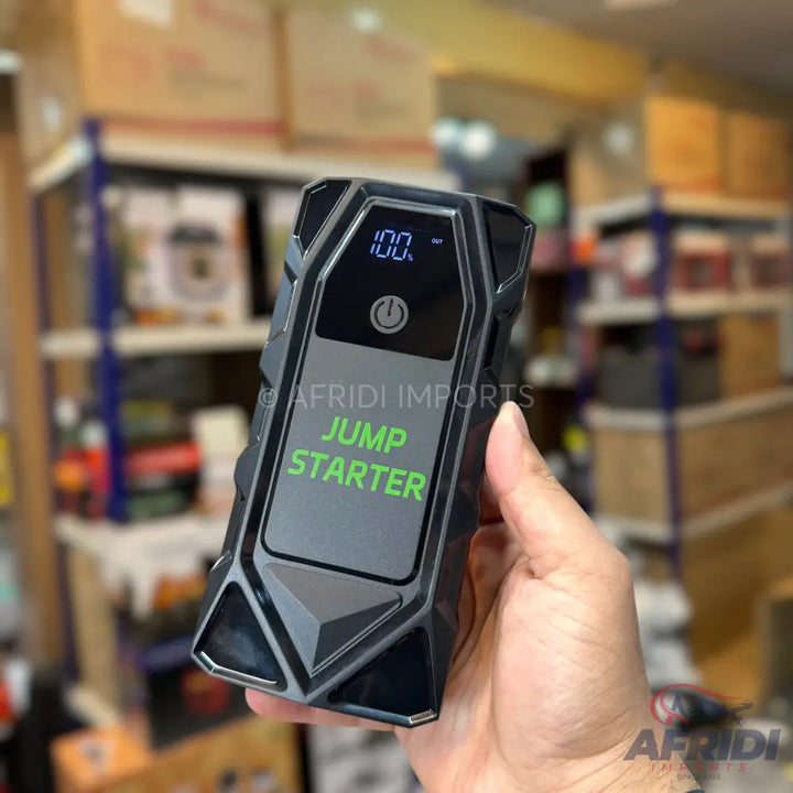 Black portable car jump starter with a digital display.