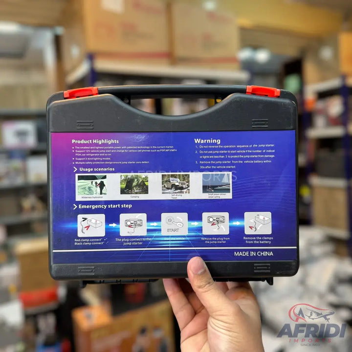 A black portable jump starter kit with product highlights, usage scenarios, and emergency start steps printed on its packaging.