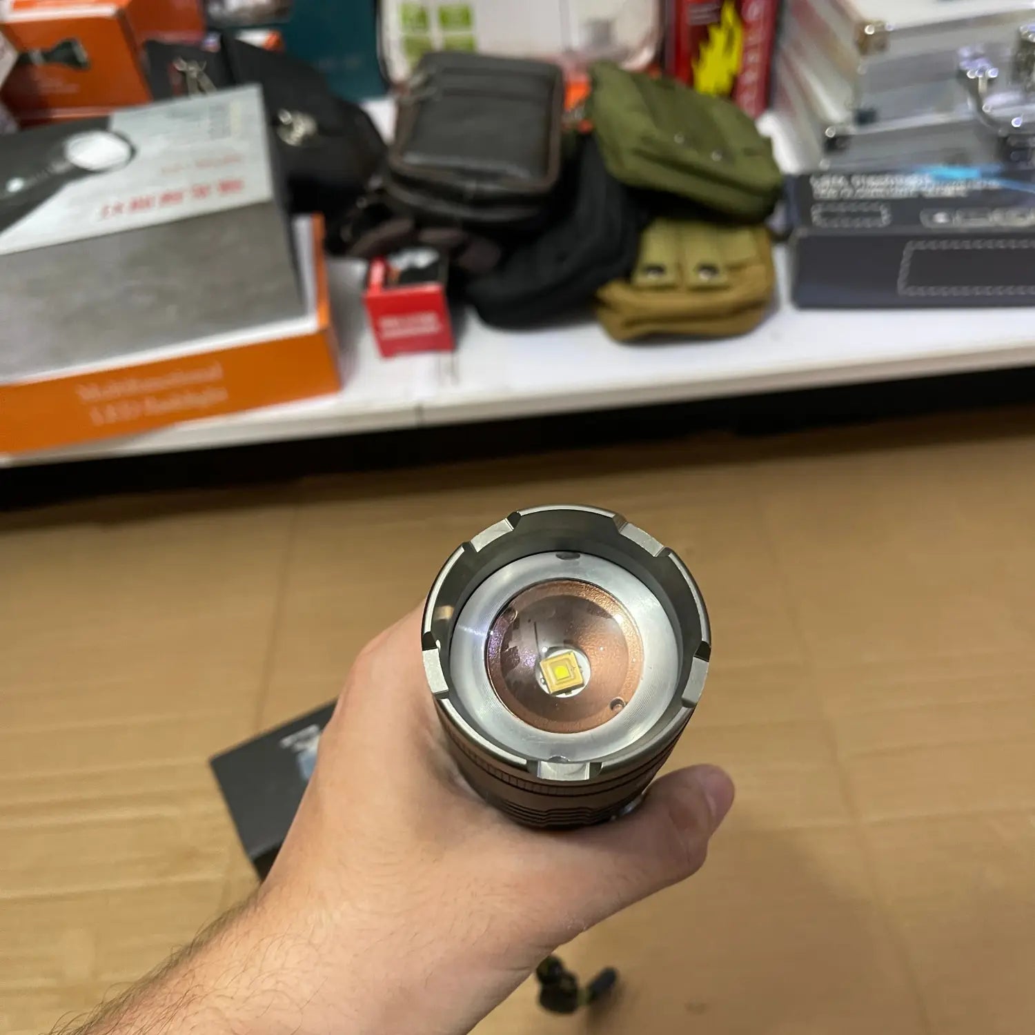 Hand holding imported high beam flashlight with visible LED emitter for powerful illumination