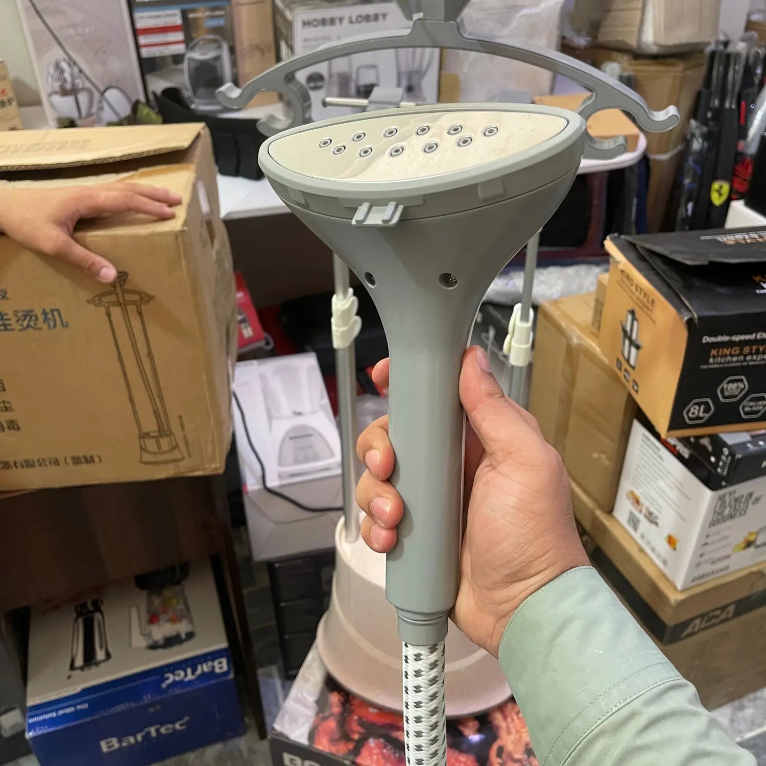 Handheld professional garment steamer with gray head and handle for efficient clothing care