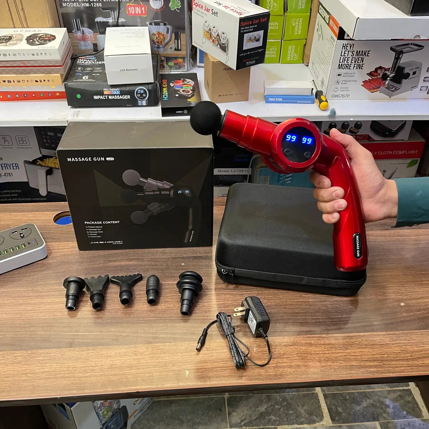Red folding massager gun Le8 with interchangeable heads and charging cable for effective therapy