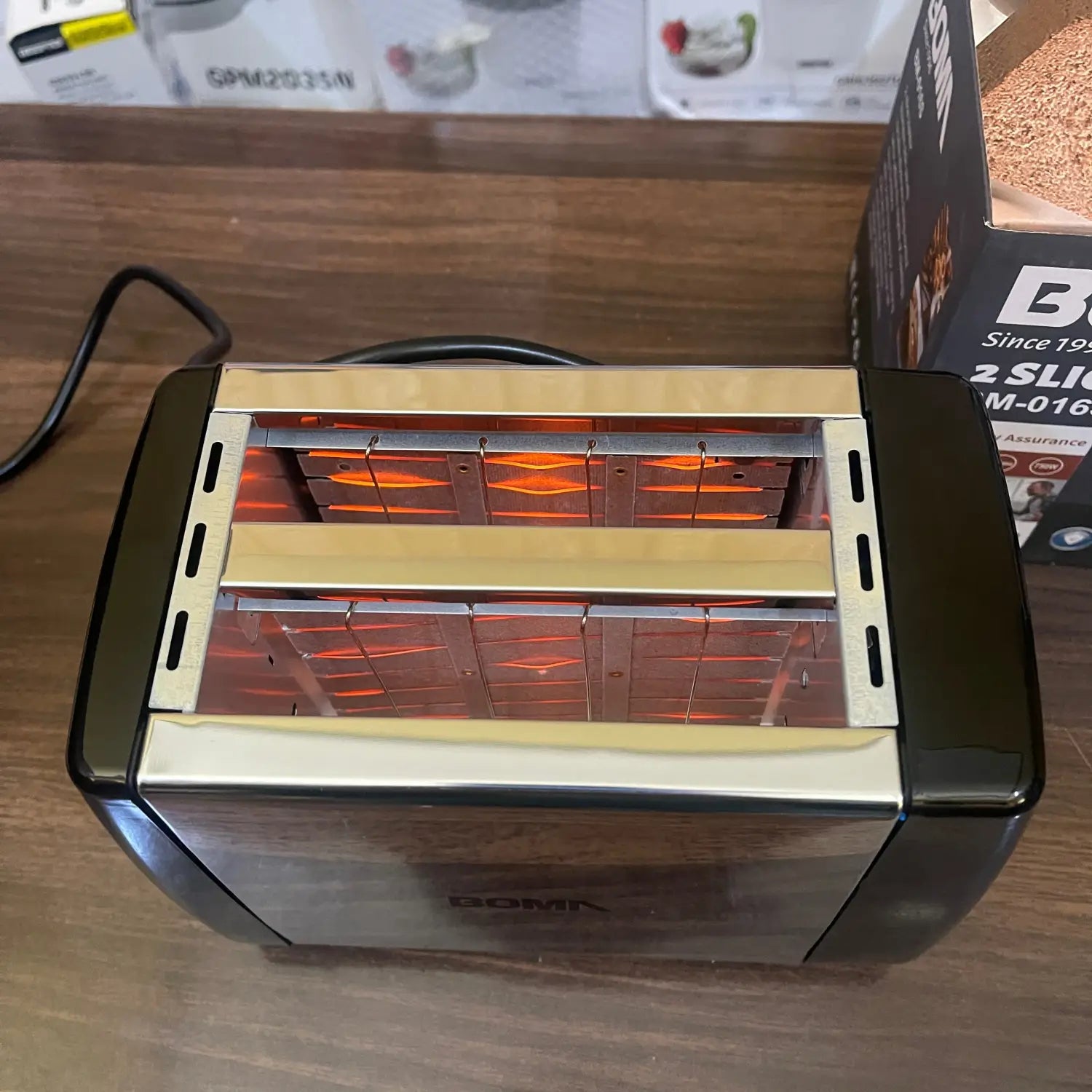 Imported Boma Mini bread toaster with black and silver finish and glowing heating elements