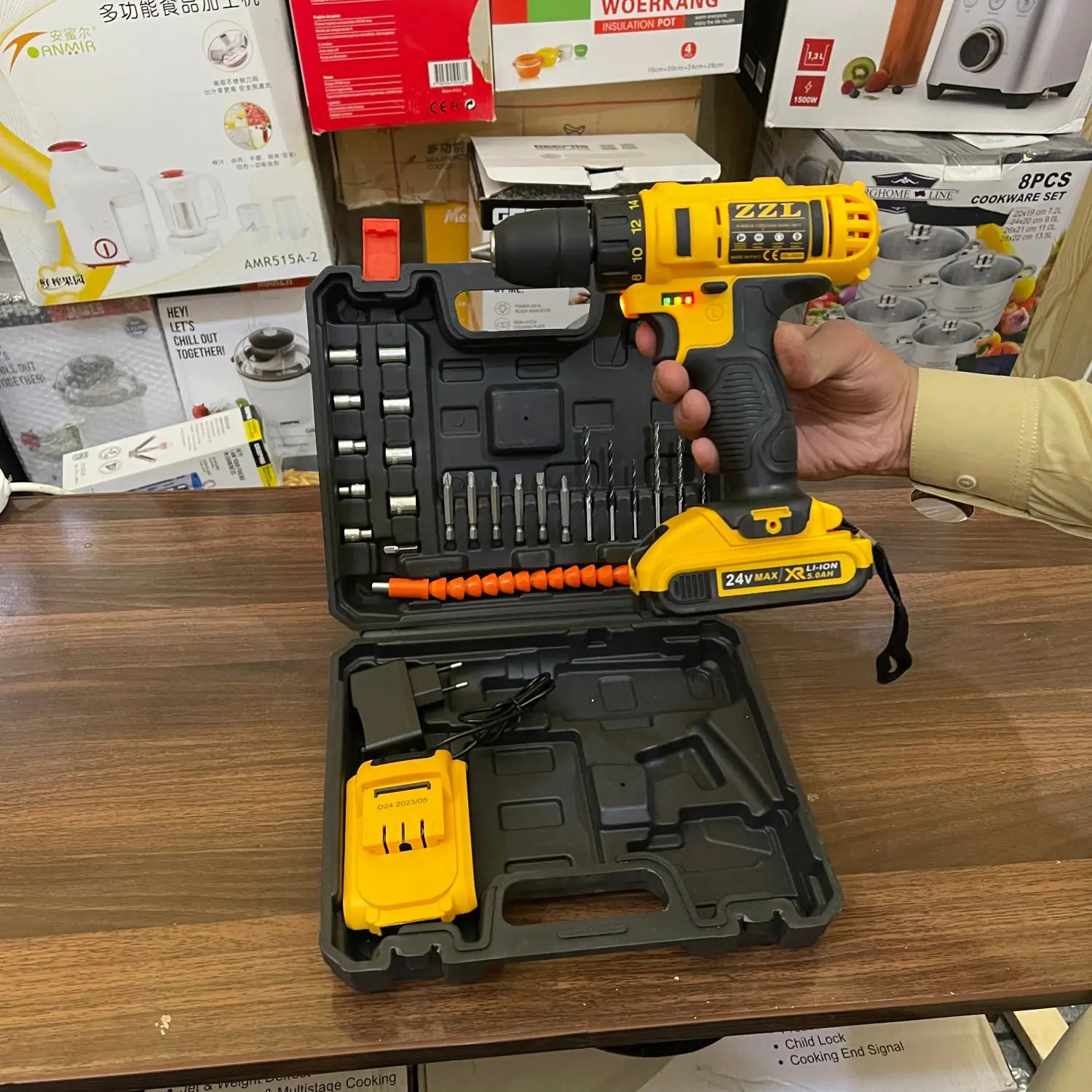 Yellow and black 24V drill machine with battery charger and drill bits in case