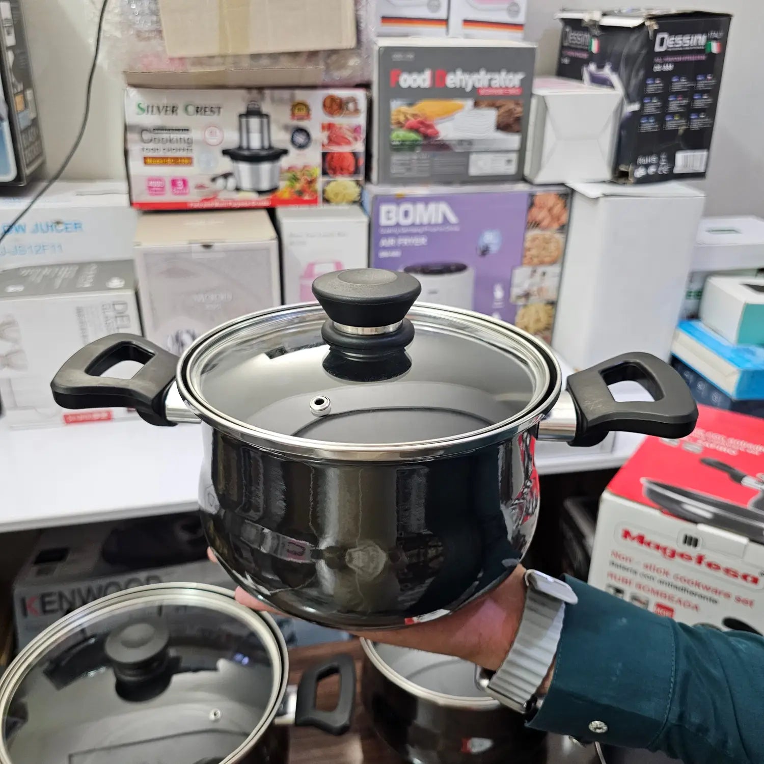 Shiny black metal cookware set with casserole size pot, handles, and glass lid